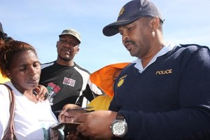 Photo of colonel Mkuseli Nkwitshi accepting a memorandum handed over by Vathiswa Dulaze and Andile Lili