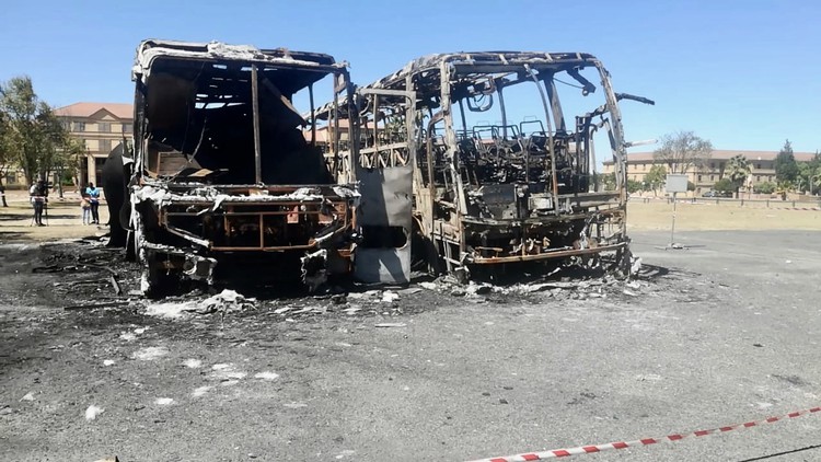 Photo of two burnt out busses