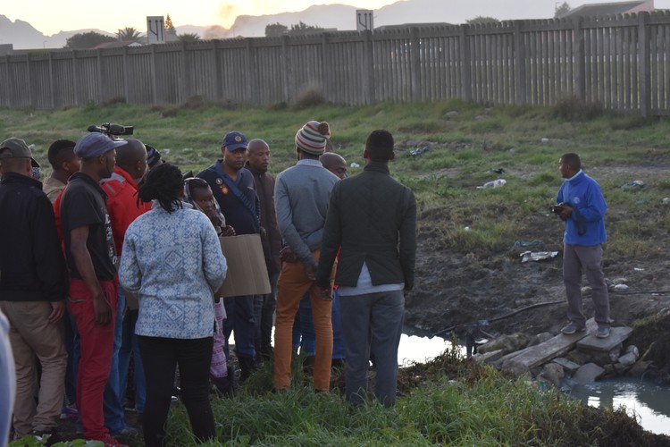 Photo of people talking to police with canal in background