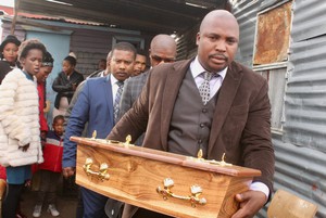 Photo of a man carrying a small coffin