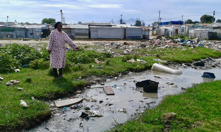 Photo of a woman pointing to raw sewage