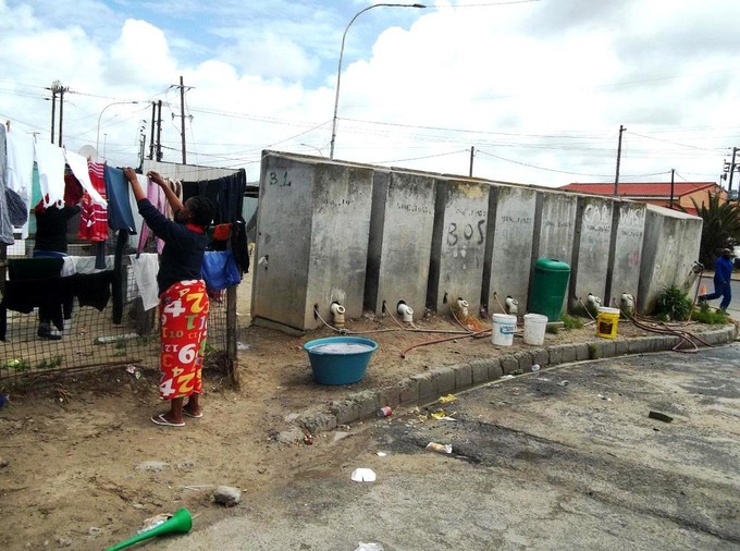 Photo of women hanging up washing near a row of toilets