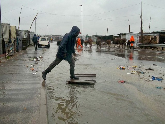 Photo of a man crossing a flooded street