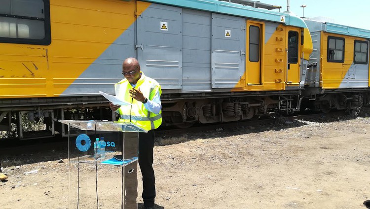 Photo of man speaking in front of train