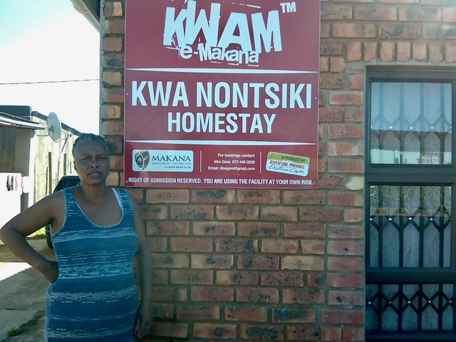 Photo of a woman with her homestay sign