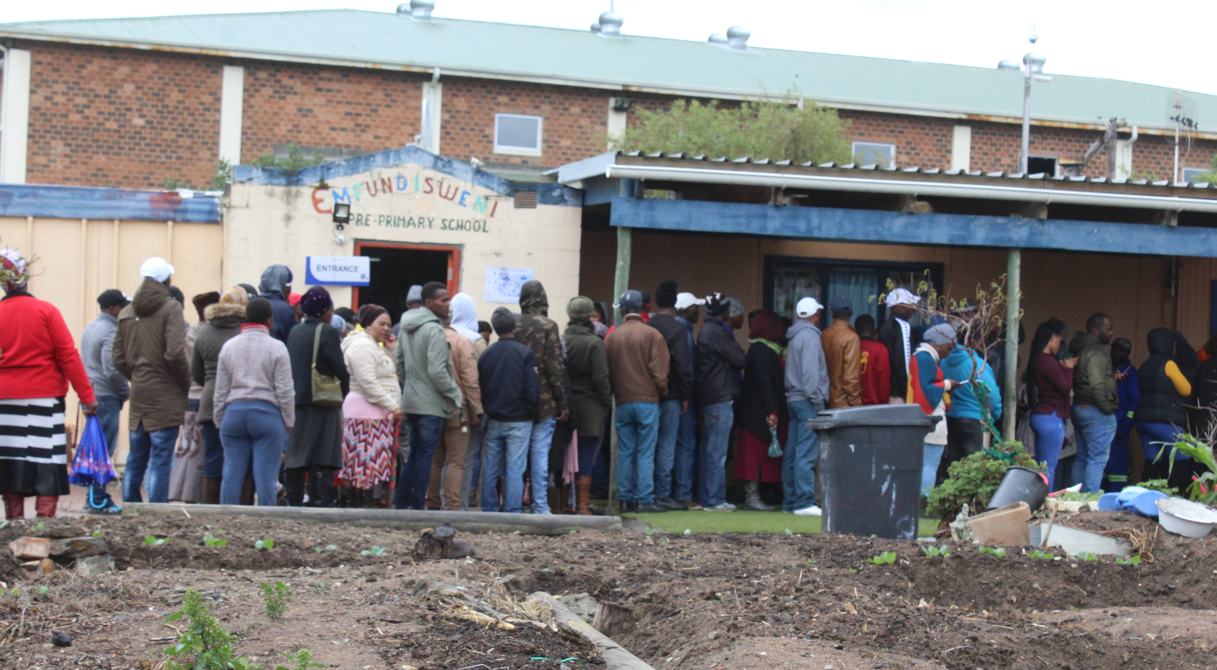 Photo of people standing queue to vote