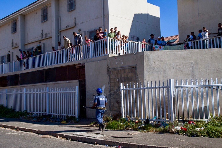 Photo of people on balconies watch police