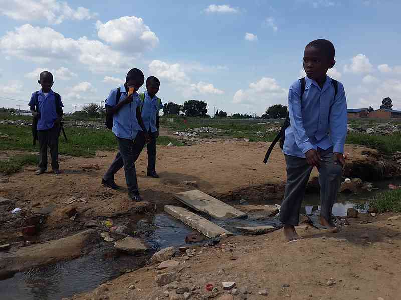 Photo of school children crossing river