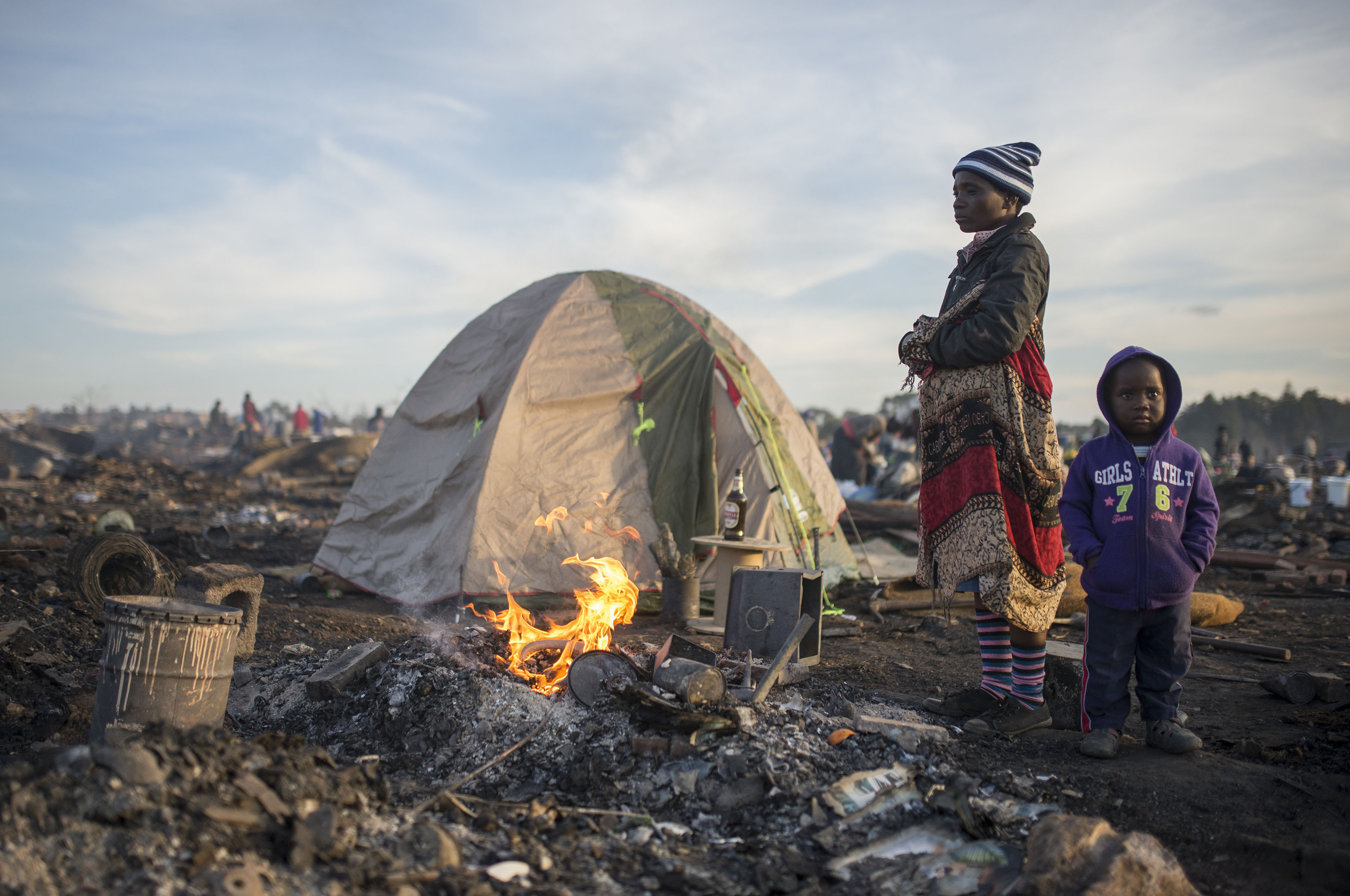 Photo of people and a tent in rubble