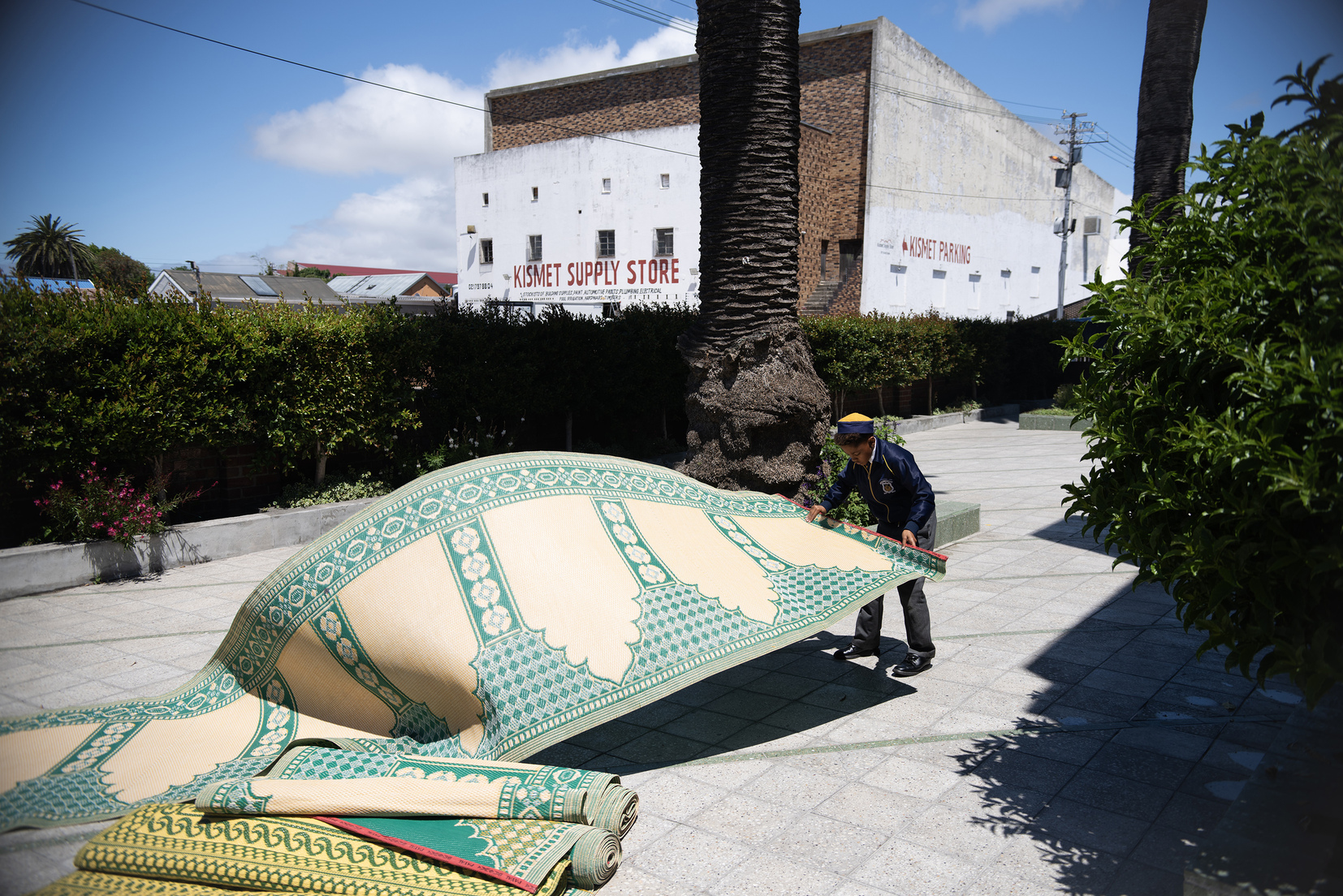 A young boy setting out prayer mats before Friday prayers in Wittebome